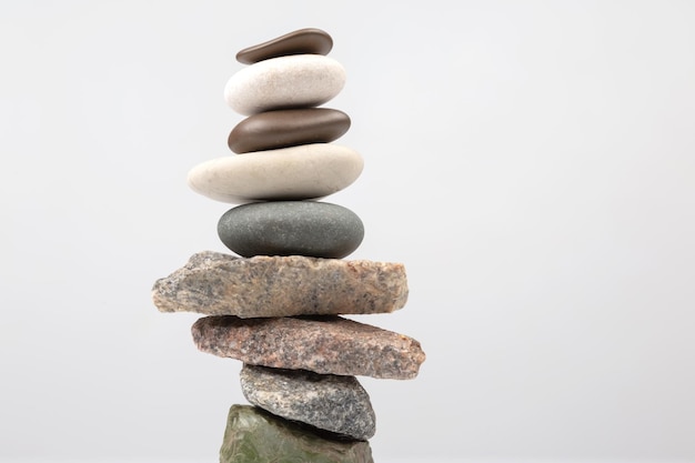 Pyramid of stacked stones on a light background stabilization and balance in life