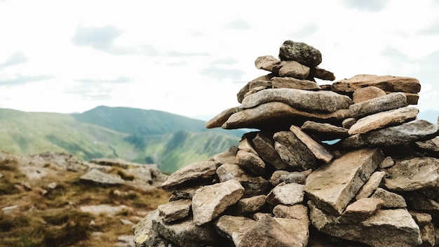 Pyramid of stones on the background of green mountains