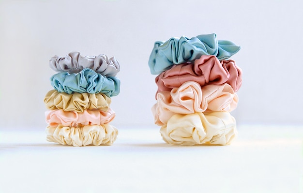 Pyramids of silk beige scrunchies on white luxury hair accessories elastic bands bobble hairband