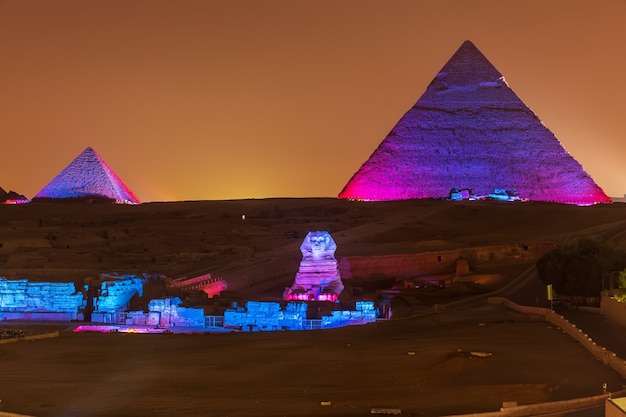 Photo the pyramids and the sphinx in the night lights, giza, egypt.