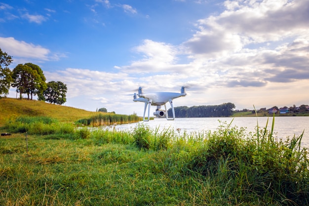 Quadcopter drone flying with a camera over a lake.