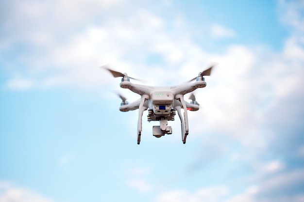 Quadcopter drone with the camera against the blue sky