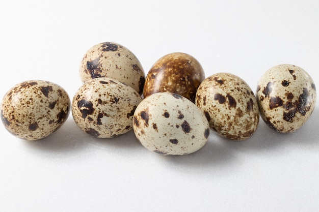 Quail eggs close up on white background.