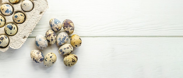 Quail eggs laid out on white wooden table near cardboard tray Ecofriendly packaging Farm products