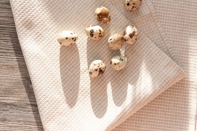 Quail eggs lie on a linen towel on a gray table in the kitchen of the house