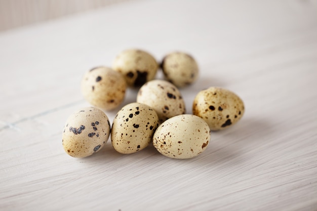 Quail eggs on white wooden table. Selective focus