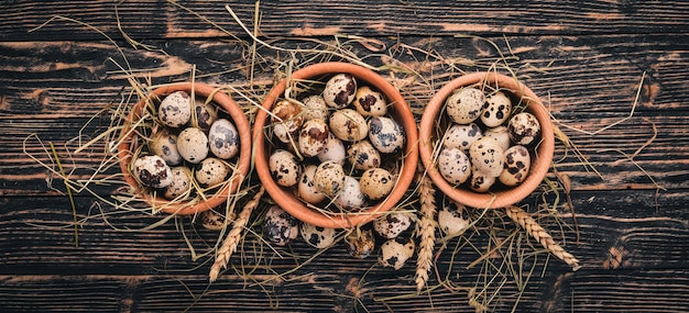 Quail eggs in a wooden bowl On a wooden background Top view Copy space