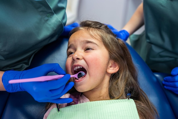 Qualified dentists treat teeth on a small child's dental chair