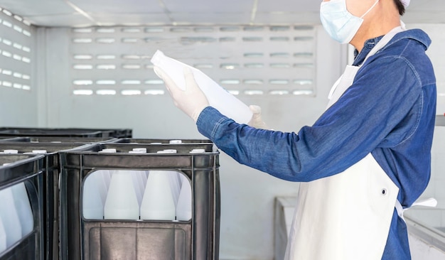 The quality inspector in workwear working in checking bottled drinking water in drink water factory