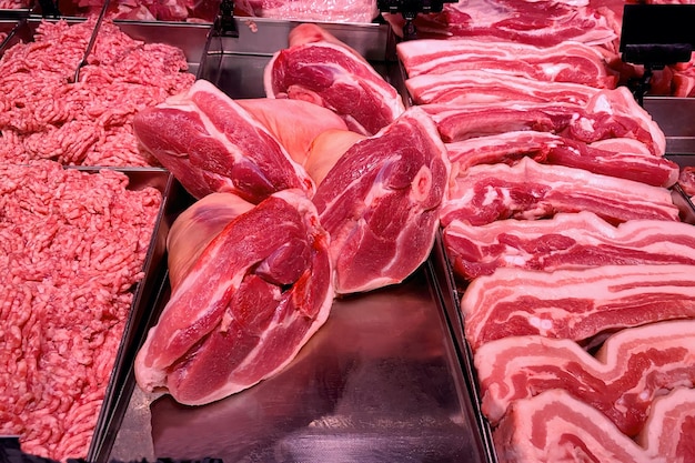 Quality various fresh raw pork meat in fridge showcase at modern butcher shop