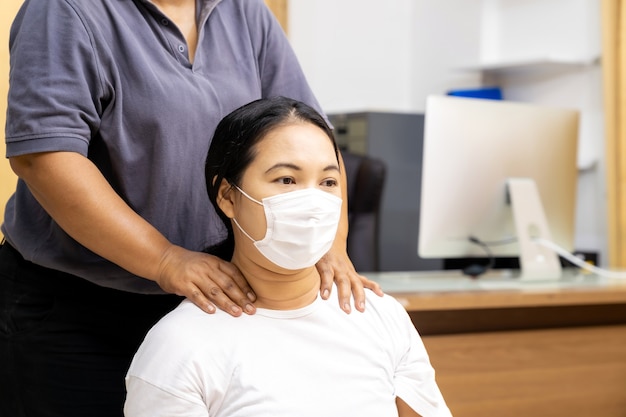 Quarantine asian woman do massage at home with face mask