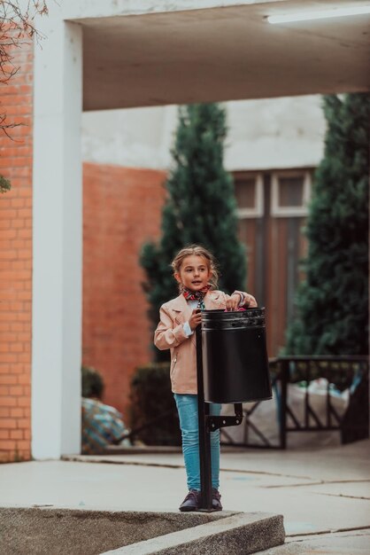 Quarantine is over concept Girl throwing away protective face mask to garbage trash can on background of blooming parkEnd of covid19 pandemicfreedomvictorywin Selective focus High quality photo