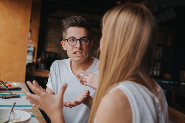 Quarrel between two young people in a coffee house, in a bar or restaurant