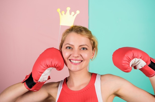 Queen of boxing ring Sportswoman with princess crown Cheerful girl with crown prop in boxing gloves Athletic woman winner Victory concept Sport success Achieve success Celebrate success