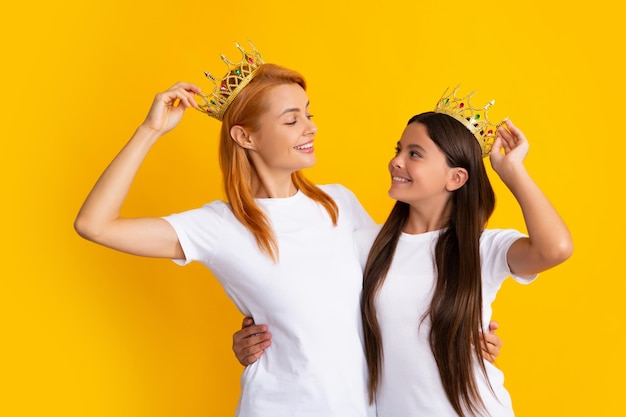 Queens in tiara Funny family on a yellow background Mother and her daughter girl with crown Two princess