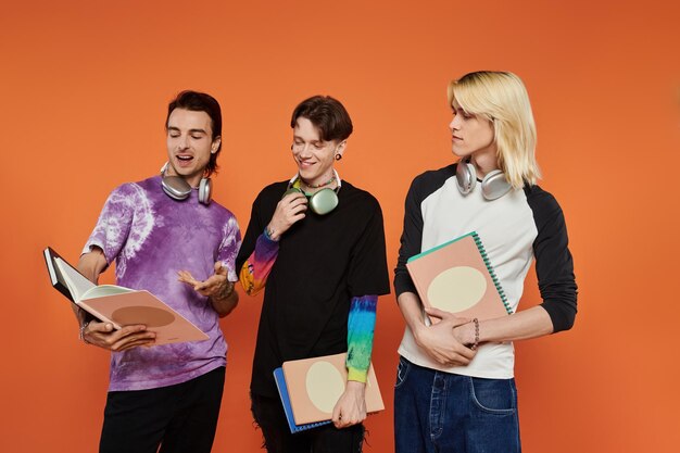 Photo queer friends in vibrant attire against orange wall