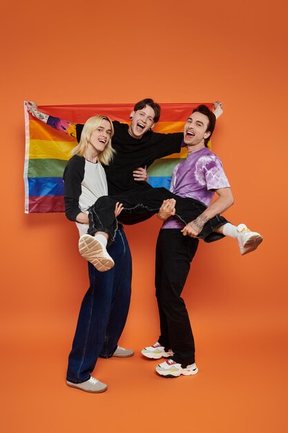 Photo queer joy three friends pose with pride flag