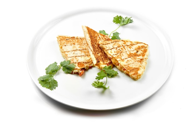 Quesadilla with cheese and chicken in a white plate Closeup selective focus White background