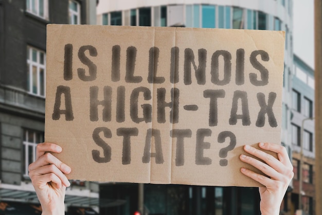 The question Is Illinois a hightax state is on a banner in men's hands with blurred background Cost Budget Crisis Decision Earnings Freedom Interest Revenue