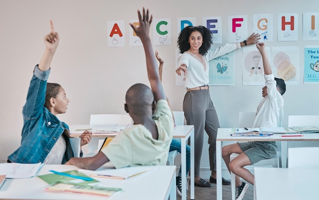 Question learning and education at school with kids hands raised to answer alphabet assessment Classroom learners and tutor teaching a summary information in a class with smart and clever group