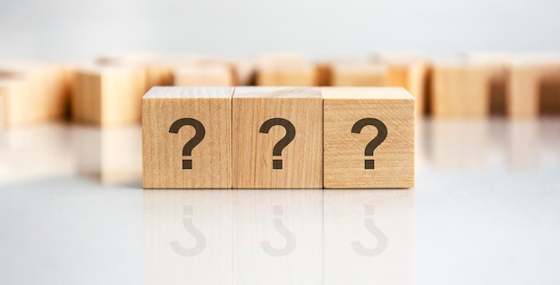 Question mark shown on three wooden cubes on a grey background