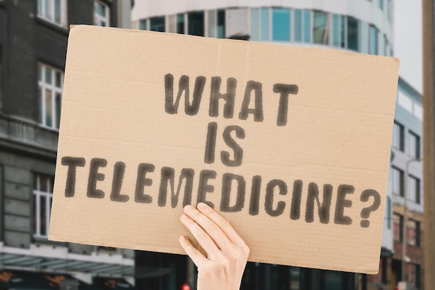 The question What is telemedicine is on a banner in men's hands with blurred background Diagnostic Discussion Exclusive Expertise Health Care Job Health Digital Laptop Confidence