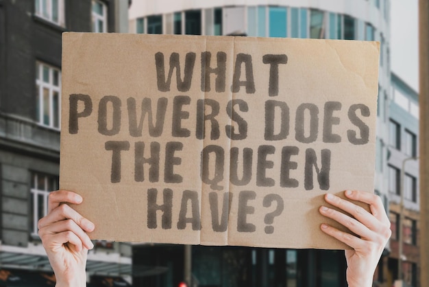 The question What powers does the Queen have is on a banner in men's hands with blurred background Strategy Ego Nobility Majesty Historical Work Business Career Greatness Strategic