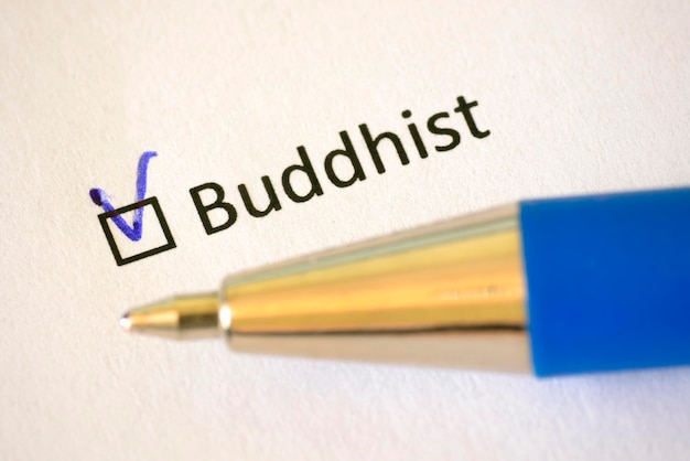 Questionnaire Blue pen and the inscription BUDDHIST with check mark on the white paper