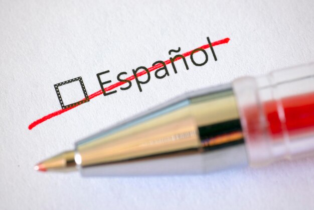 Questionnaire red pen and the crossed out inscription Spanish on the white paper