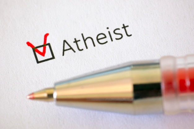 Questionnaire Red pen and the inscription ATHEIST with check mark on the white paper