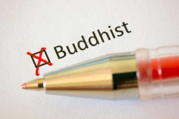 Questionnaire Red pen and the inscription BUDDHIST with cross on the white paper