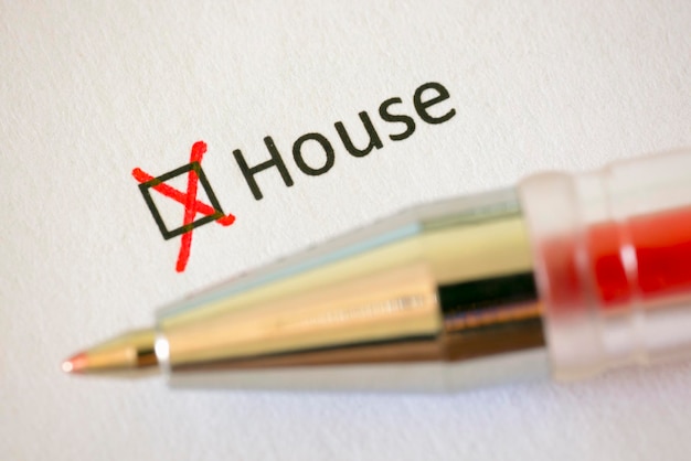 Questionnaire Red pen and the inscription HOUSE with cross on the white paper