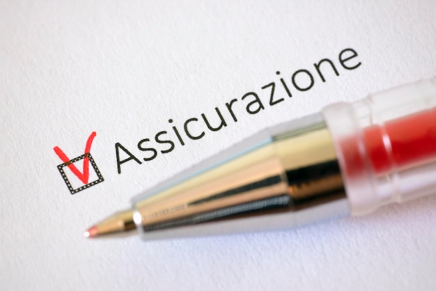 Questionnaire red pen and the inscription INSURANCE with check mark on the white paper