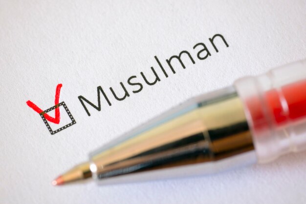 Photo questionnaire red pen and the inscription muslim with check mark on the white paper