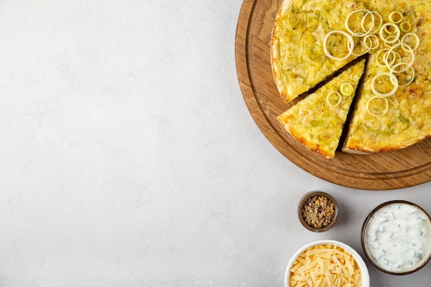 quiche pie with leek potatoes and cheese flat lay on gray concrete background with copy space