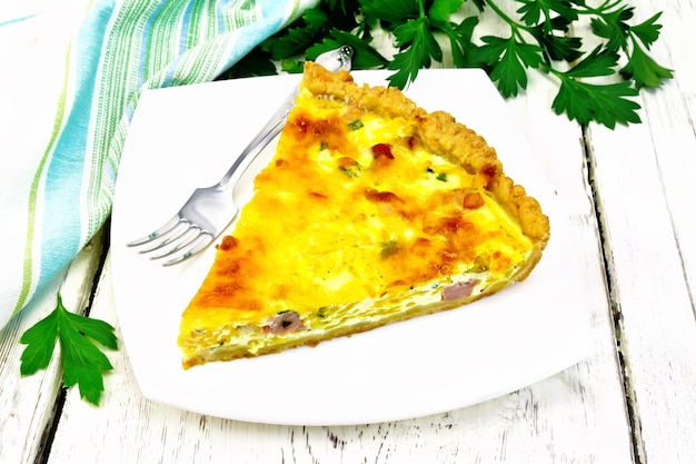 Quiche with pumpkin and bacon in white plate on table