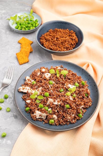 Quinoa porridge with green pea and chicken on ceramic plate on a gray concrete background Side view