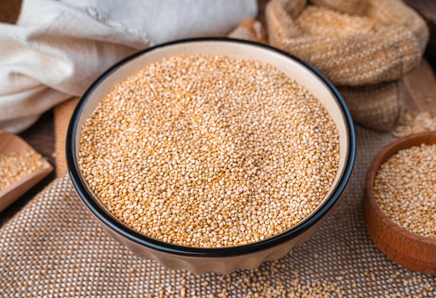 Quinoa seeds in a bowl closeup on a wooden background Side view Healthy food