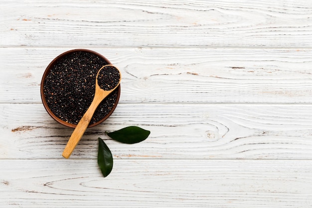 Quinoa seeds in bowl and spoon on colored background Healthy kinwa in small bowl Healthy superfood