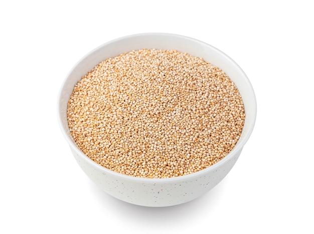 Quinoa seeds in a white bowl are isolated on white Side view closeup