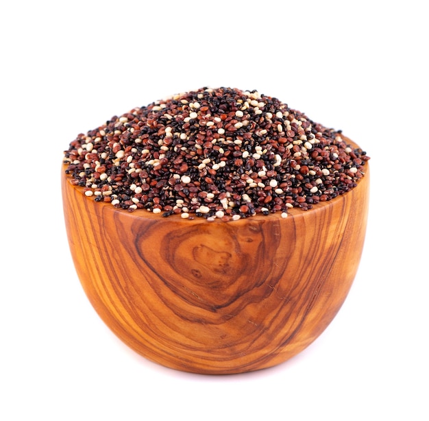 Quinoa seeds in wooden bowl isolated on white background Mix of white red and black quinoa