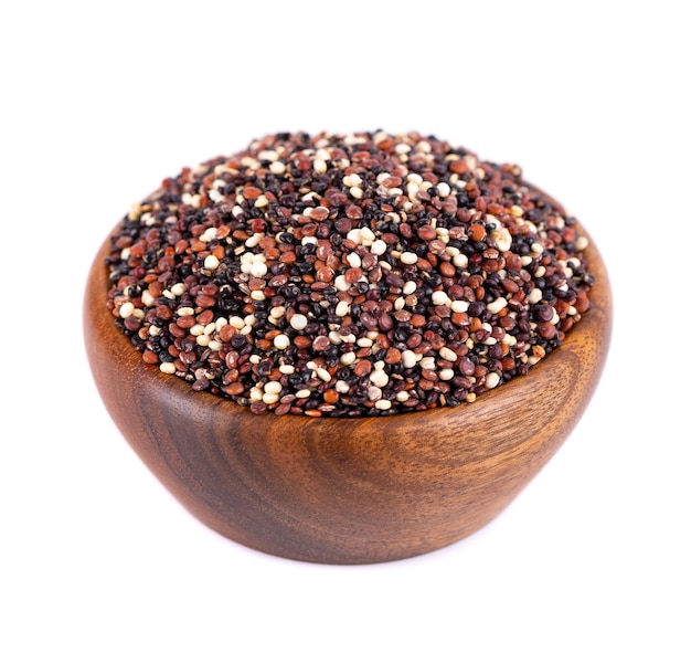 Quinoa seeds in wooden bowl isolated on white background Mix of white red and black quinoa