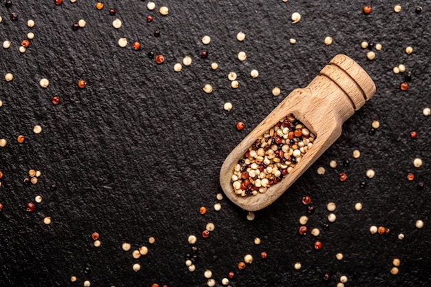 Quinoa seeds in wooden scoop on a stone background diet superfood product banner menu recipe place for text top view