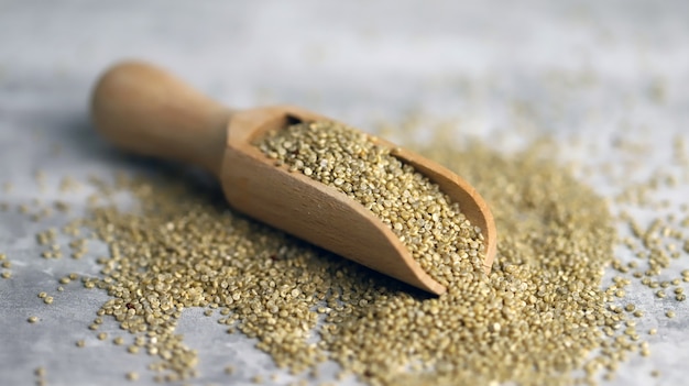 Quinoa seeds in a wooden spatula.