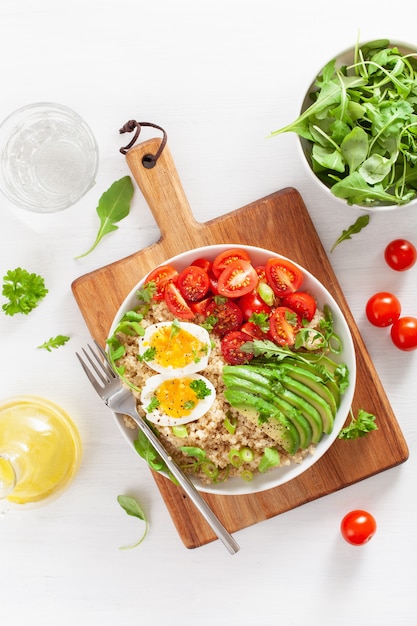 Quinoa with boiled egg, avocado, tomato, arugula. healthy breakfast