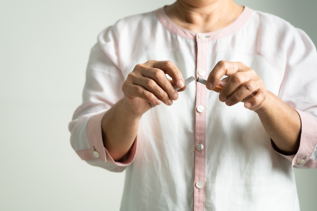 Quit smoking, no tobacco day, mother hands breaking the cigarette