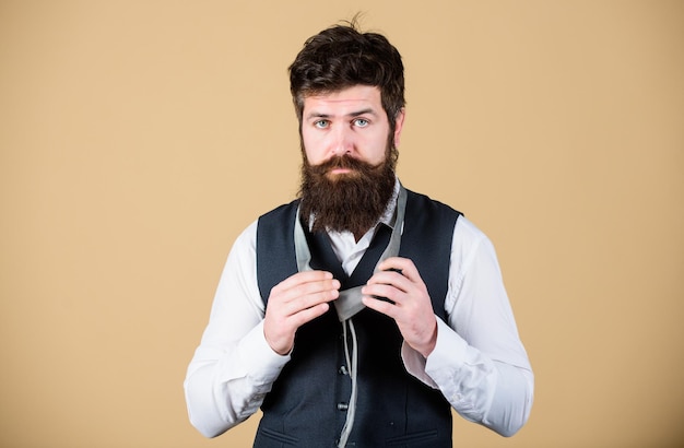 Quite formal Fashionable man Bearded man tying a necktie Brutal caucasian man adjusting fashion accessory Man with long beard and moustache dressing in classic style