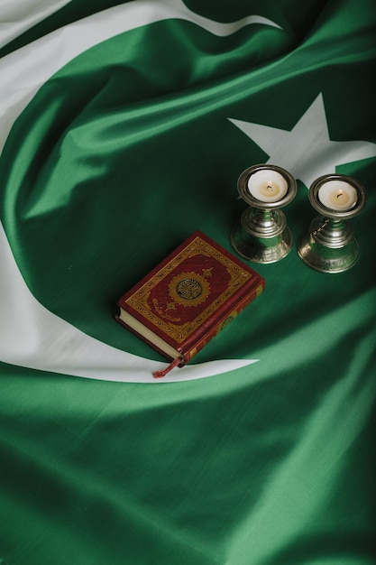 Quran and candles on a flag of Pakistan