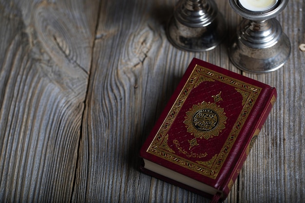 Quran and candles on a wooden surface Translation into English the book contains verses of Koran