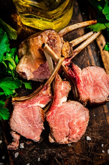 Rack of grilled lamb on a wooden cutting board with parsley